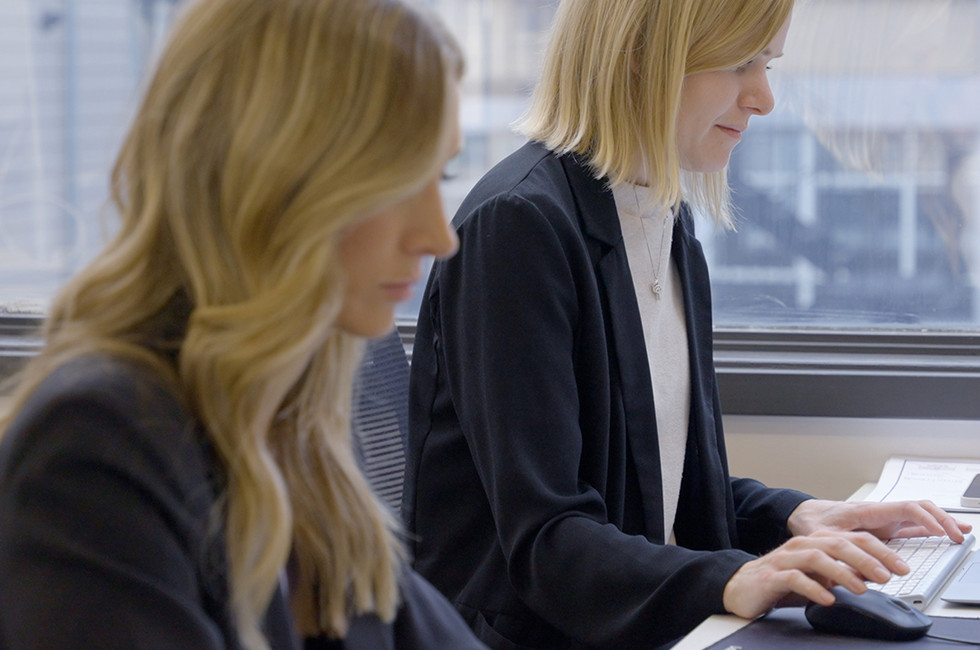 Two employees trying to reconcile employee credit card expenses manually instead of using a corporate expense management solution. 